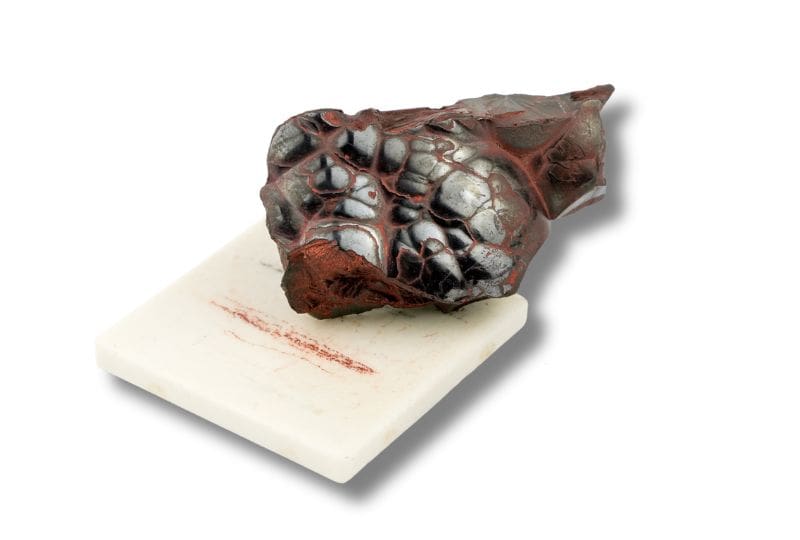 Dark hematite with reddish-brown streaks on a porcelain test plate.