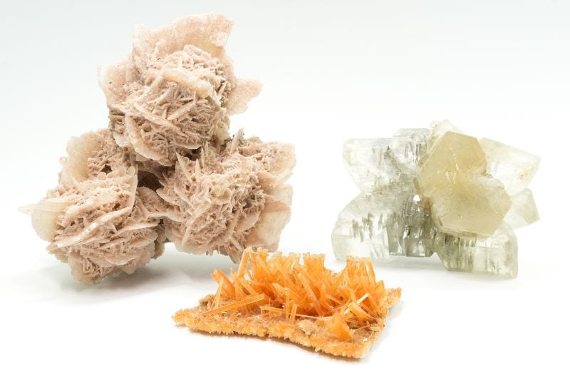 Various growth forms of gypsum: elongated and plate-like crystals, and rosette-shaped desert roses.
